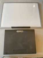 Whiteboard mounted on wall above travel desk showing front of both items.