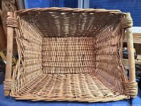 View inside the bottom of the rectangular woven wicker laundry basket showing its shape and weave detail.
