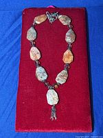 Full view of chunky agate and jasper necklace laid flat on red velvet background