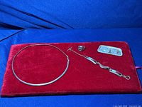 Full lot displayed on red velvet background showing necklace, spinner ring, bracelet, and brooch pin arranged separately.