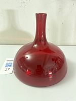 Front and side views of the ruby red glass bottle vase showing its full form and color.