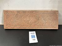 Full front view of rectangular terracotta fireplace tile showing overall embossed peacock and foliage design
