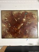 Frontal view of the large surrealist oil painting showing the winged central figure and ghostly faces around it.