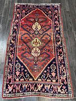 Full view of the Persian Hamadan rug showing orange background with dark blue borders and decorative medallion design.