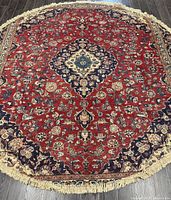 Top view of circular rug showing full medallion design and red field