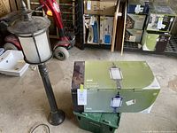 Assembled exterior lamp post next to boxed lamp post