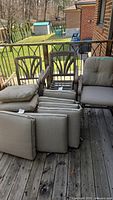 Set of metal patio chairs stacked and beige cushions arranged in front, showcasing chairs and cushion condition and quantity