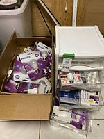 Box filled with numerous Philips LED bulbs in purple packaging, mostly 60W equivalent 9W LED standard bulbs.