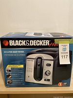 Front view of boxed Black & Decker Home deep fryer indicating 2.0-Liter capacity, digital countdown timer, and product features.