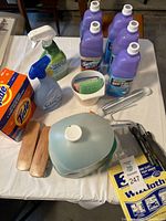 Full view of lot showing Swiffer solution bottles, detergent, spray cleaners, brushes, sponges and Wizzcloth cloths.