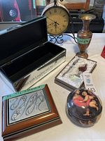 Photo of all lot items including clock, vase, letter opener, magnifying glass, circular decorative box and rectangular box with embossed metal top.