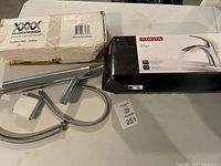 Photo showing both faucets with packaging, Delta Nyla box and Magicwoods box with faucet and accessories.