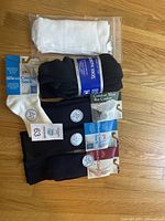 Photo of six pairs of new diabetic socks in various colors, some with original tags, one pair sealed in plastic bag.
