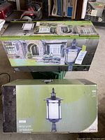 Two boxed exterior lamp posts by Globe, Sun series, showing packaging and branding