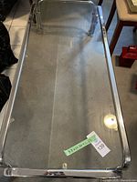 Full view of the coffee table with glass top and chrome frame showing its rectangular dimensions and style.