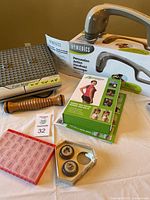 Overview of the health improvement lot including foot massager, wooden rollers, pill boxes, and Posture Medic box.