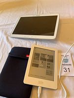 Samsung tablet and Kobo eReader on beige surface with black Verso sleeve