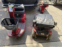 Two assembled red Celebrity X mobility scooters side by side showing front baskets, seats, foot platforms