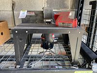 Front view of the Sears/Craftsman router table with mounted router, power cord visible underneath, and red plastic guard placed on the surface