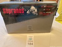 Front view of The Sopranos Complete Series DVD box set sealed in shrink wrap showing title, number of episodes, discs, and bonus features.