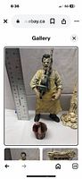 Front view of Leatherface figure standing approximately 6 inches tall holding chainsaw with bucket accessory and size reference ruler