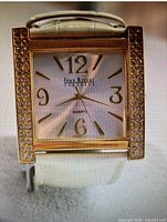 Front view of Joan Rivers Classics watch showing rectangular gold-tone case with crystals and white dial with gold-tone numbers and hands.