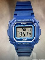 Blue Casio digital watch front showing time, date, and water resistant markings.