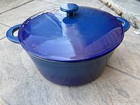 Blue cast iron pot with lid shown from top angle highlighting blue enamel lid and handles.