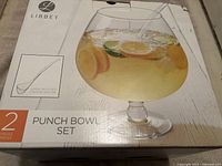 Box of Libbey brand new punch bowl set showing the punch bowl filled with a beverage and fruit slices, as well as included ladle.