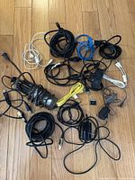 Lot of assorted cords laid out showing cables of various types and colors, including an under counter bulb with protective cage