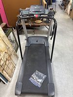 Top-down view of the treadmill showing running belt surface and handrails with a plastic bag on belt surface.