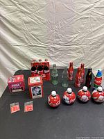 Full view of vintage Coca-Cola bottles and metal tins arranged on a cloth