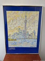 Framed poster showing Toronto skyline with CN Tower and sailboats, signed McMurtry, marked 1994 CBA Toronto.