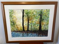 Front view of framed watercolor painting on wall showing wooden frame and mat