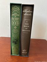 Spine view of two Folio Society books with titles The Adventures of Robin Hood and Abraham Lincoln: A New Birth of Freedom