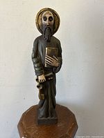 Front view of carved wood statue of Saint Peter holding a book and keys, showing carved details and aged patina.