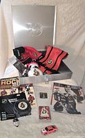 Full lot overview showing multiple Ottawa Senators items including jersey, plush mascot, collectible puck, toy car, collectible cards, and NHL 2004 sticker album
