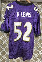 Back view of purple Baltimore Ravens Ray Lewis jersey showing name R. LEWIS and number 52 in white with gold outline