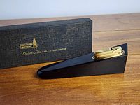 Bentley Butane Decor-Lite table or desk lighter shown from side angle with original box behind it on wood surface.