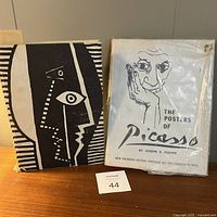 Front covers of both books side by side on table with lot tag visible