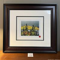 Framed print with dark wood frame and white mat showing colorful landscape scene with lake and autumn foliage.