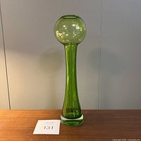 Front view of the tall green glass vase showing its full height and bulb top opening.