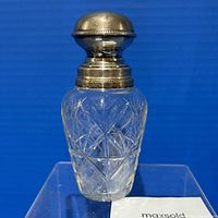 Front view of clear cut glass perfume bottle with sterling silver top, showing detailed diamond and crosshatch pattern on glass body and rounded sterling silver cap with beaded edge.
