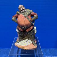 Front view of Falstaff figurine on clear stand against blue backdrop.