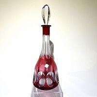 Front view of Kaspar Bleikristall red cut to clear decanter showing the clear faceted stopper and the cut to clear red glass design.