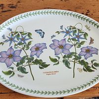 Top view showing the full Clematis Florida flower design with butterflies and green leaf border on the platter.