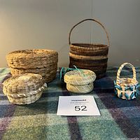 Front view of the five small woven indigenous baskets on a blanket