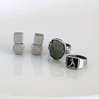 Full view of three sterling silver jewellery pieces: geometric clip-on earrings, green stone ring, football ring