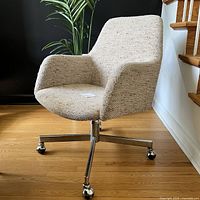 Three-quarter front view of tweed upholstered swivel office chair on chrome star base with casters