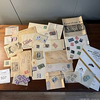 Wide view of collection showing stamps, covers, envelopes, clippings, and catalogues arranged on table.
